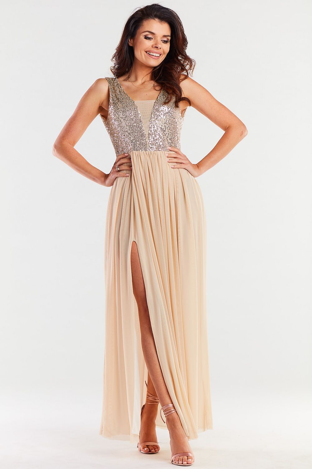 Stylish long beige dress adorned with sparkling sequins and flowing fabric, showcasing an elegant silhouette ideal for special occasions.