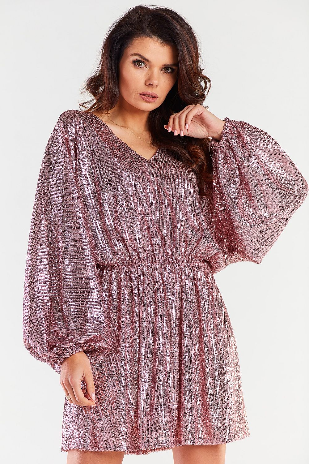 Elegant loose evening dress in shimmering pink with cheeky neckline and wide sleeves, perfect for special occasions.