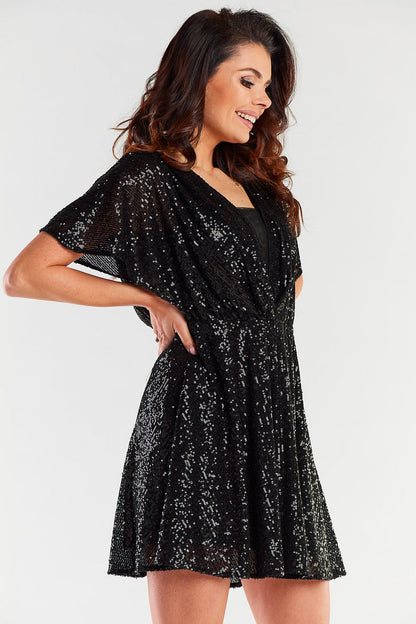 Model showcasing a stunning black sequined short dress with a fitted waist and flowing skirt, highlighting the exquisite detailing perfect for evening wear.