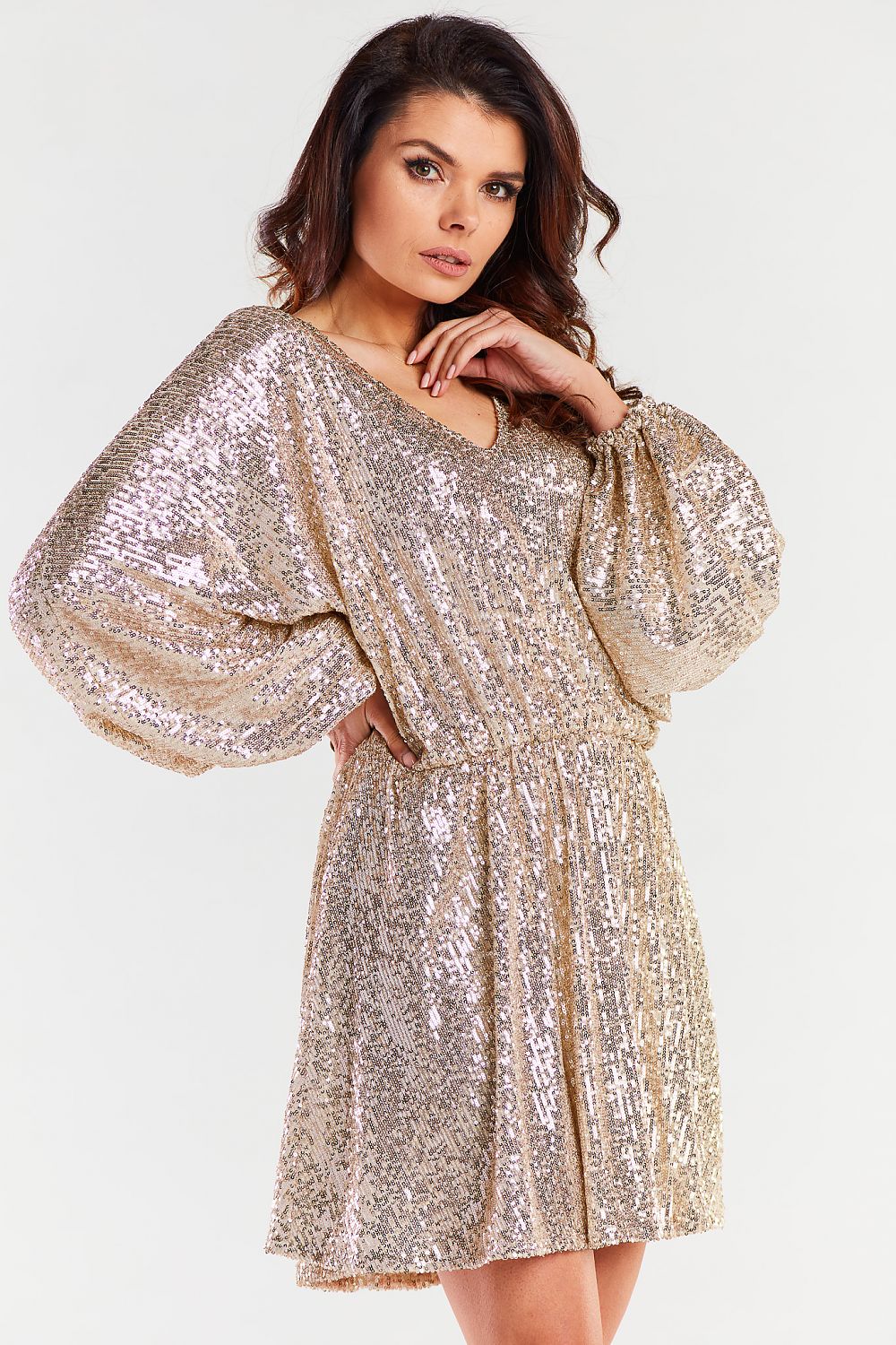 Sophisticated side view of a sparkly gold loose evening dress by Awama, showcasing voluminous sleeves and a flattering fitted waist.