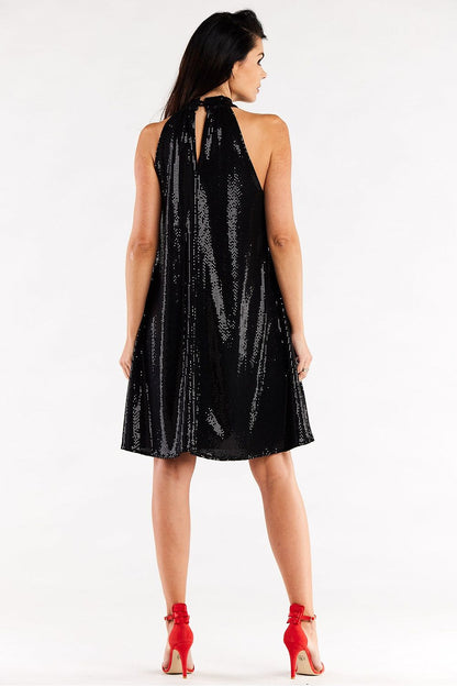 Sophisticated black evening dress with a ruffle neckline, viewed from the back, accentuated by red high heels, exuding elegance.