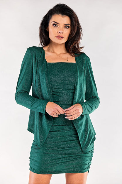 Elegant model wearing a rich green Awama bedspread jacket with a fitted dress, accentuating a refined and chic look perfect for evening occasions.