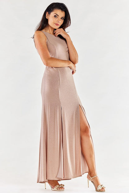 Model elegantly poses in a light pink long dress by Awama with front slits, exuding sophistication.