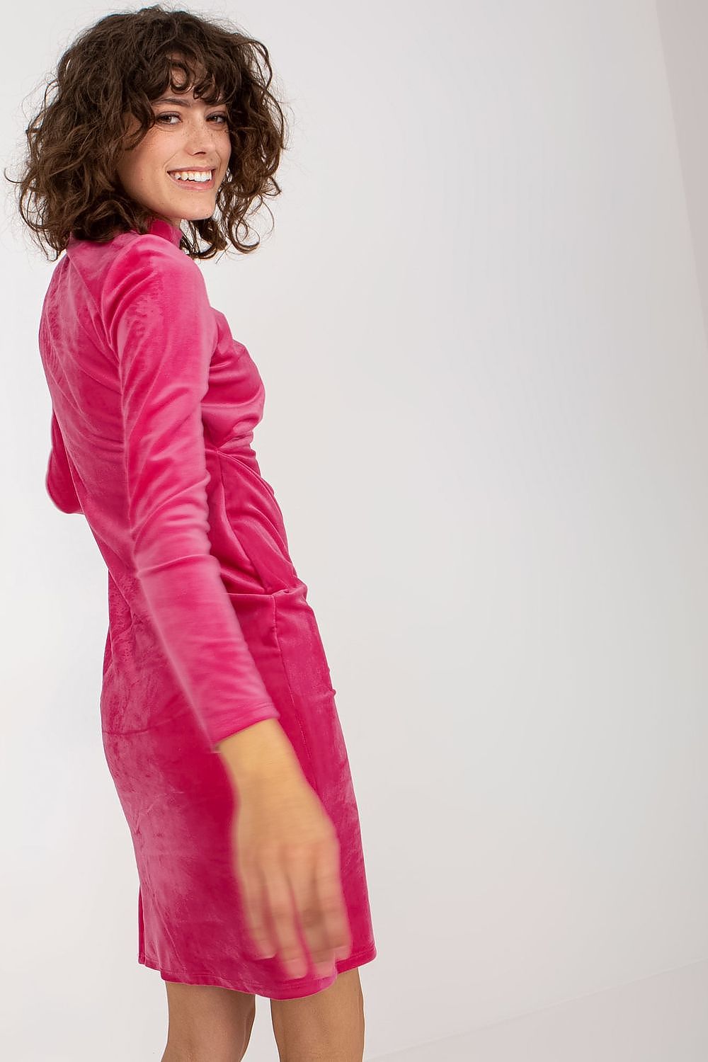 Chic side view of a luxurious velvet evening dress by Rue Paris, showcasing its long sleeves and sleek design in bold pink.