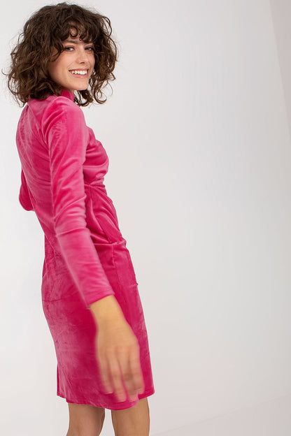 Chic side view of a luxurious velvet evening dress by Rue Paris, showcasing its long sleeves and sleek design in bold pink.