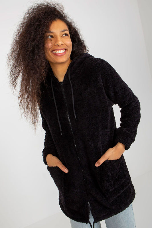 Luxurious black fur zip-up sweatshirt with hood, featuring large slip pockets, modelled by a woman with curly hair, exuding elegance and warmth.