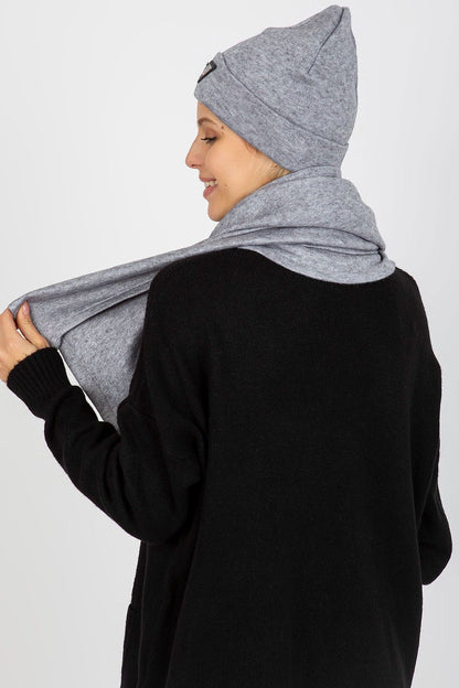 Rear view of a stunning model dressed in a luxurious grey Angora and spandex winter set, featuring a fashionable hat and scarf, highlighting the elegant drape of the scarf.