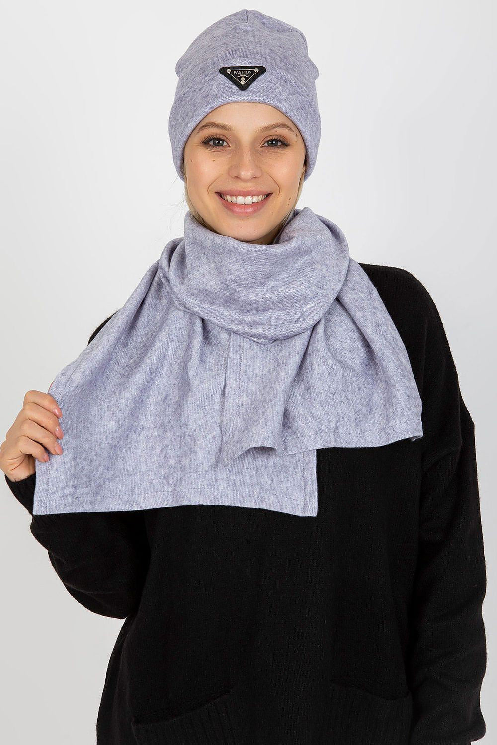 Elegant woman wearing a light grey luxurious winter set comprising an angora and spandex hat and scarf, showcasing a beautiful smile.