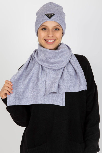 Elegant woman wearing a light grey luxurious winter set comprising an angora and spandex hat and scarf, showcasing a beautiful smile.
