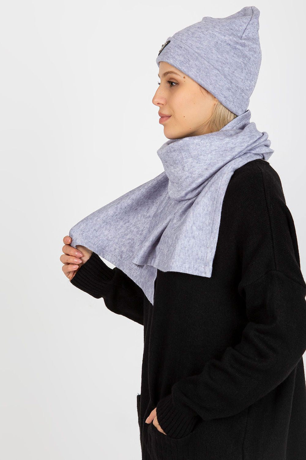 Side profile of a stylish woman in a luxurious light grey angora and spandex hat and scarf, draped gracefully around her neck.