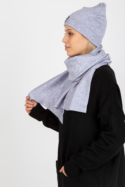 Side profile of a stylish woman in a luxurious light grey angora and spandex hat and scarf, draped gracefully around her neck.