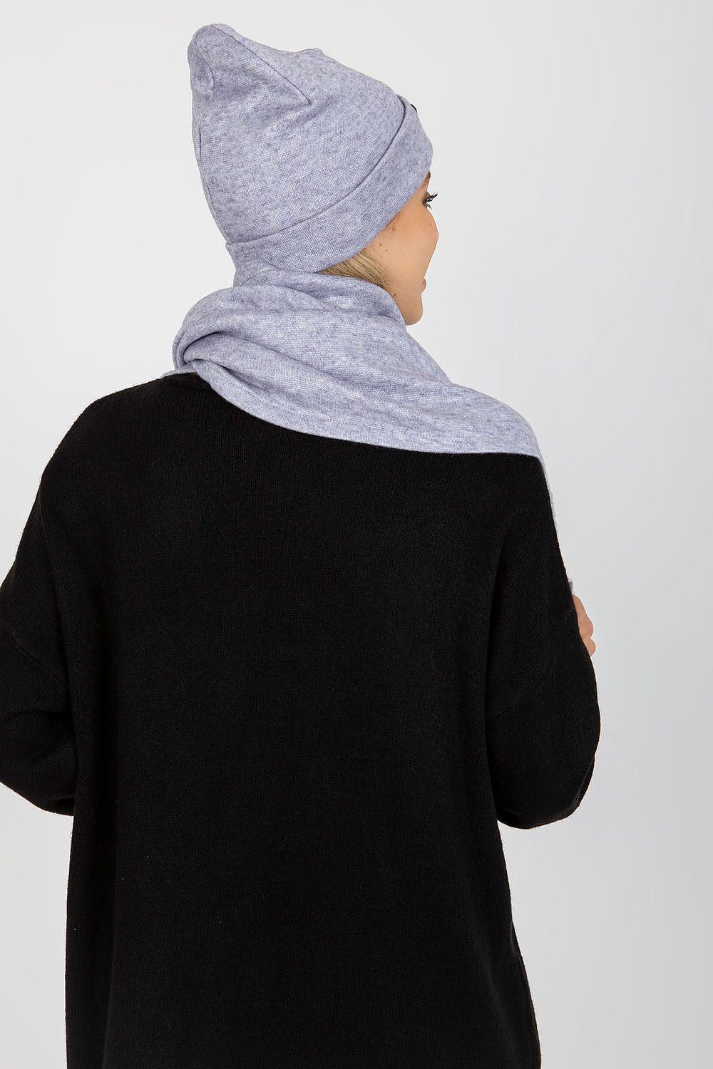Back view of a fashionable woman wearing a luxurious light grey angora and spandex winter hat and scarf, displaying refined elegance.