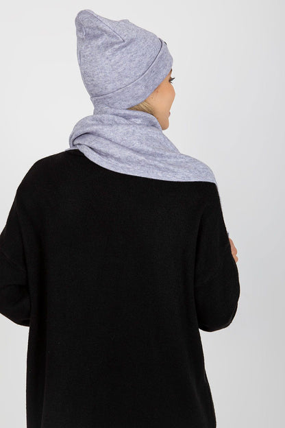 Back view of a fashionable woman wearing a luxurious light grey angora and spandex winter hat and scarf, displaying refined elegance.