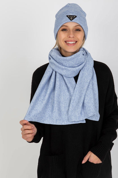 Charming woman smiling while showcasing a light blue luxurious angora and spandex winter set, including a hat and scarf.