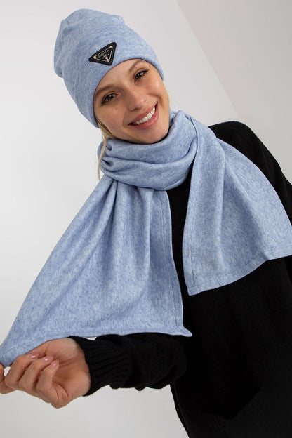 Joyful woman in a light blue luxurious winter set featuring an angora and spandex hat and scarf, presenting a warm and inviting expression.