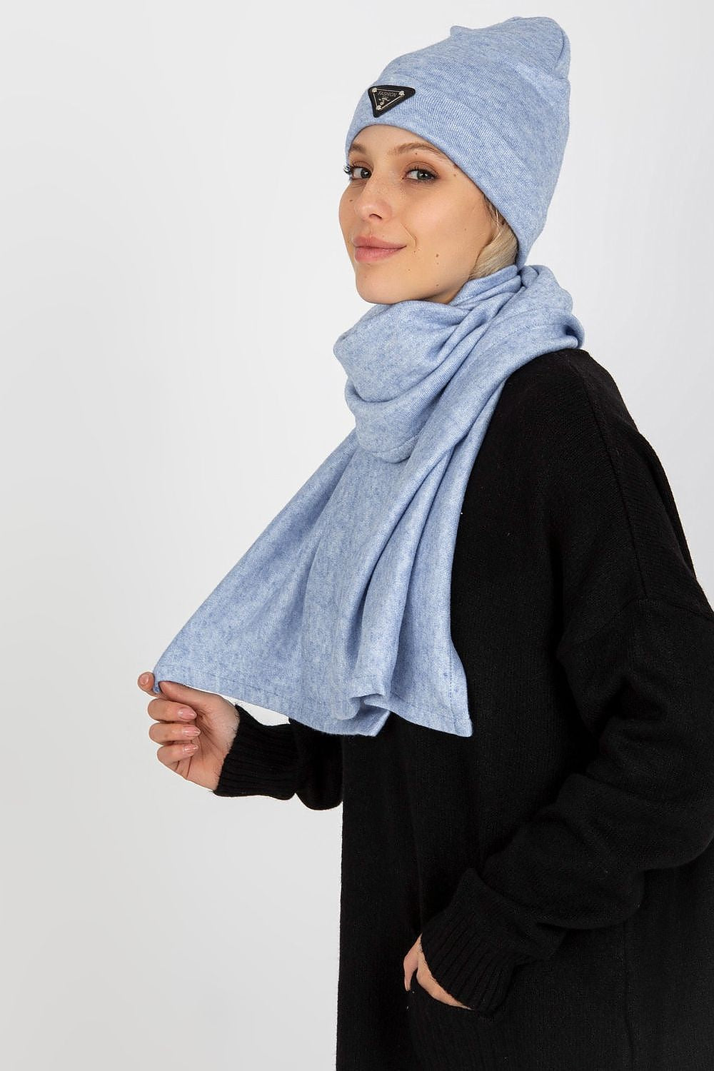 Close-up of an elegant woman wearing a luxurious blue Lakerta Angora and Spandex winter hat and scarf, styled with a black oversized sweater, highlighting the chic design and soft texture.