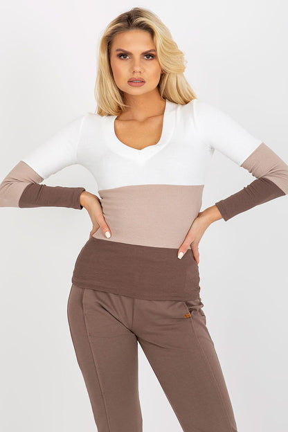 Chic women's ribbed blouse by Rue Paris featuring a v-neck and long sleeves, styled with elegant earth-toned trousers. Perfect for sophisticated casual outings.