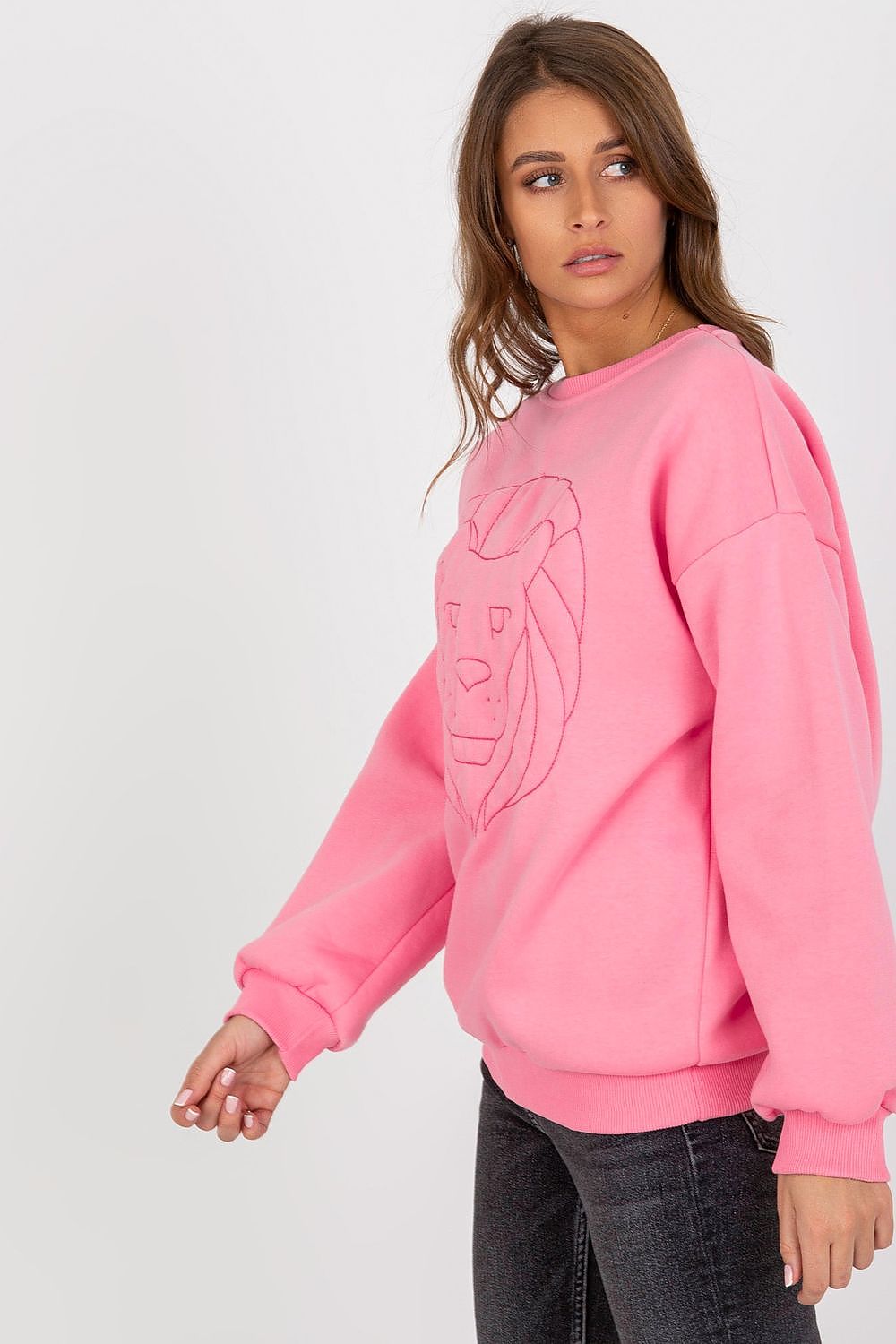 Fashionable side view of a pink sweatshirt adorned with an embroidered lion, offering a luxurious yet relaxed look.