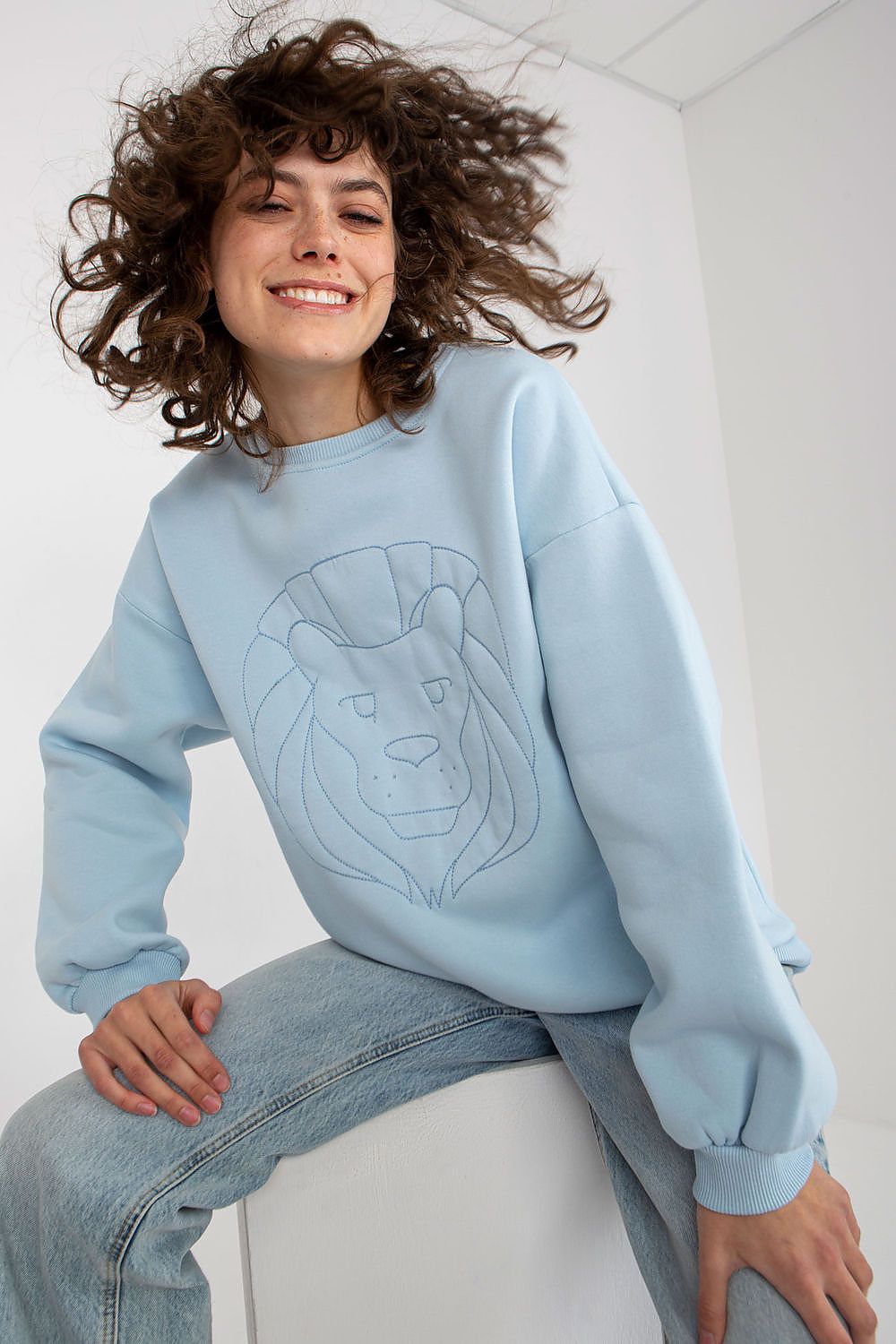 Vibrant blue women's sweatshirt with striking lion embroidery, exuding contemporary elegance and perfect for elevating casual style.