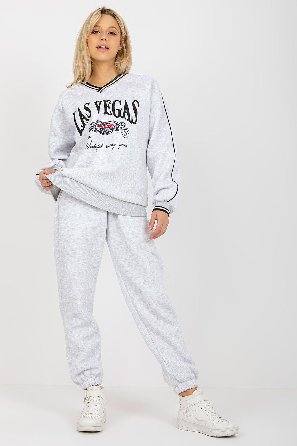 Luxurious grey cotton blend sweatshirt set showcasing a bold 'Las Vegas' print, paired with relaxed-fit pants and chic white sneakers for an effortlessly stylish look.