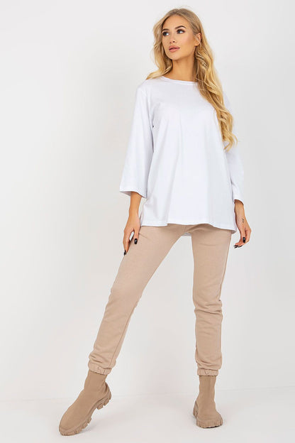 Effortlessly stylish in the Premium Ex Moda Sweatsuit, showcasing a relaxed white blouse and tailored beige pants, designed for a chic yet comfortable appearance.