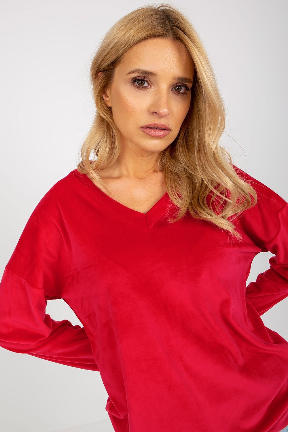 Close-up of a red velour sweatshirt for women, showcasing its elegant heart neckline and soft fabric texture.