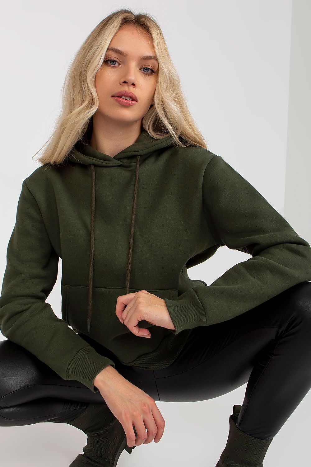 Elegant women's hooded sweatshirt in dark green, featuring a kangaroo pocket, styled with a modern look, perfect for luxury casual wear.