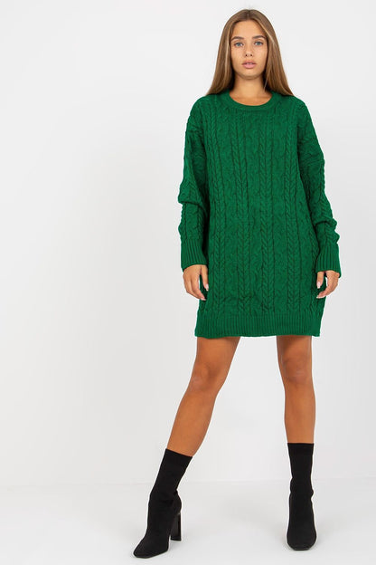 Model wearing an elegant long-sleeved green knit sweater by Rue Paris, showcasing a textured cable knit design, perfect for stylish layering over leggings.