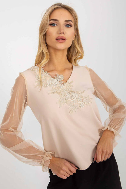 Close-up of the Lakerta blouse showcasing detailed floral embroidery on the heart neckline and sheer mesh sleeves, exemplifying luxurious style.