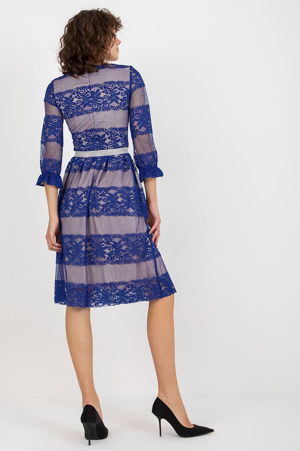 Rear view of a model wearing a sophisticated blue lace evening dress with flattering 3/4 sleeves and a tied waist sash, complemented by black high heels.