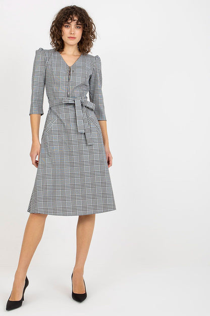 Elegant checkered daydress featuring a zip closure and a waist tie, designed for a sophisticated look. The dress is complemented by 3/4 sleeves and stylish slip pockets, perfect for any occasion.