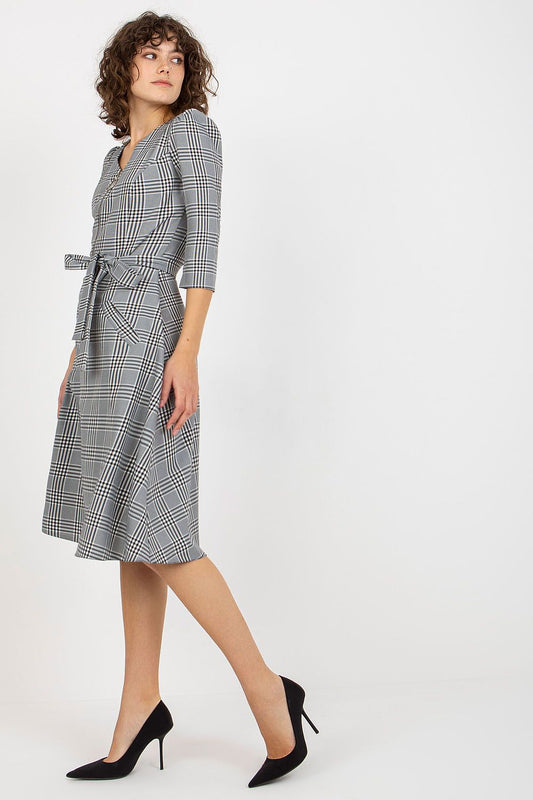 Side view of a luxurious checkered daydress with a defined waist tie and flattering cut. The dress boasts 3/4 sleeves and a chic silhouette, ideal for a refined wardrobe.
