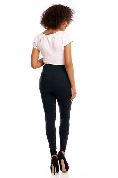 Elegant back view of a model wearing luxury black maternity leggings, highlighting tummy support and comfort, styled with a casual short-sleeve top and chic heels.