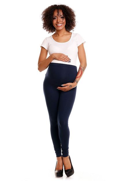 Front view of a smiling model showcasing luxury navy maternity leggings with tummy support, paired with a fitted short-sleeve top, perfect for expectant mothers.