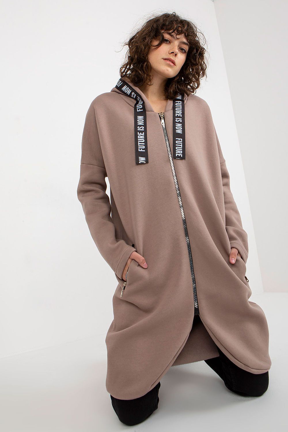 Chic luxury women's zippered hooded sweatshirt in soft taupe, featuring an extended cut and practical zippered pockets, styled elegantly on a model.