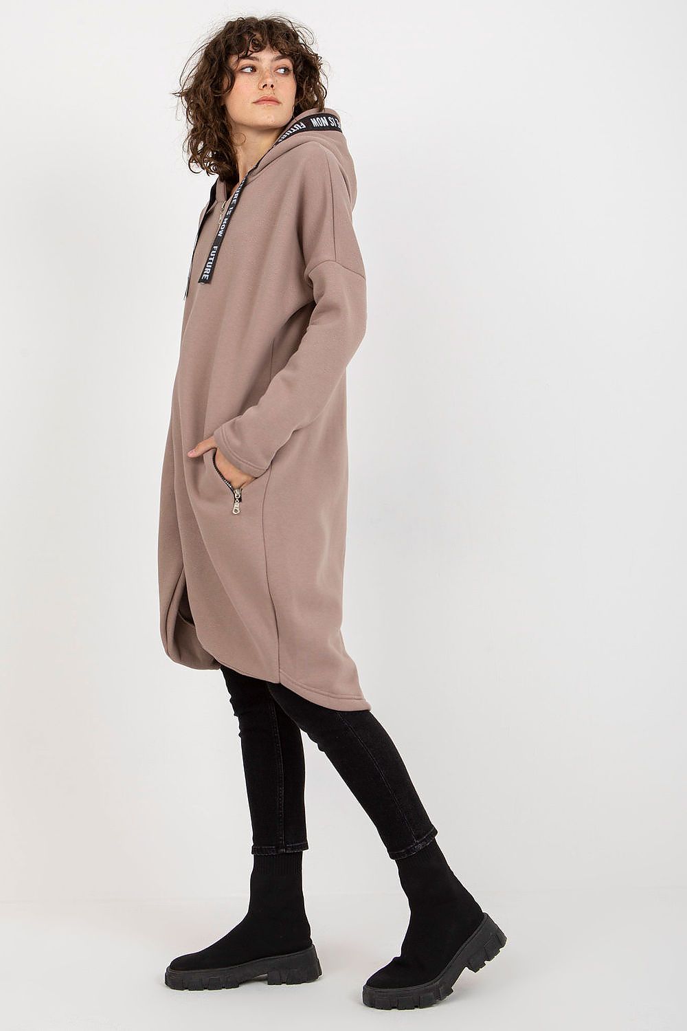 Sophisticated luxury women's zippered hooded sweatshirt in taupe, highlighting its relaxed fit and unique design, modelled with a gaze towards the side.