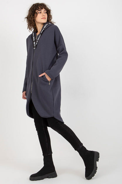 Elegant women's zippered hooded sweatshirt with a sophisticated extended cut, styled with black jeans and trendy ankle boots, ideal for a stylish casual look.