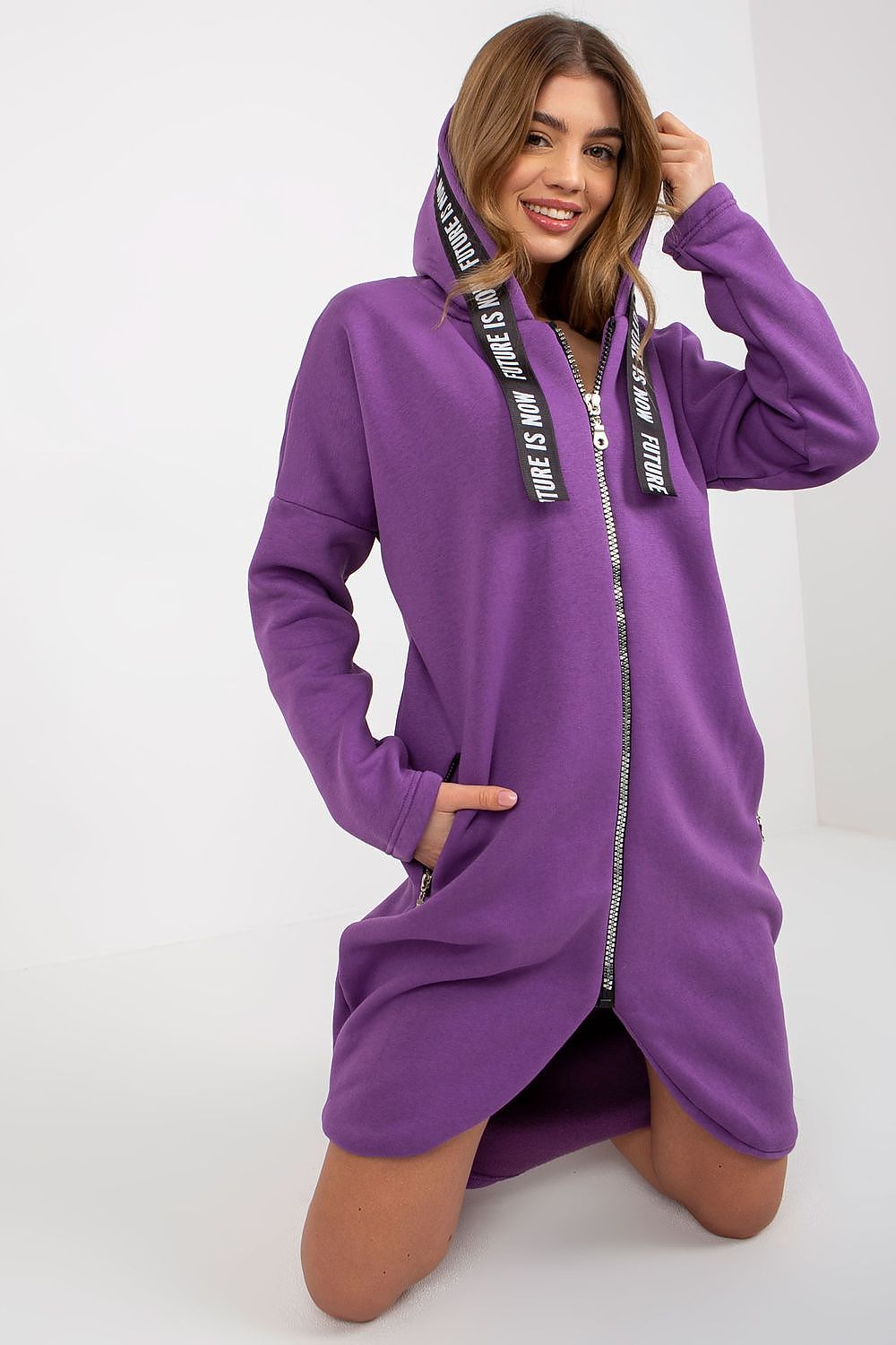 Luxurious women's purple zippered hooded sweatshirt featuring an extended silhouette and zip pockets, offering a chic and comfort-enhanced style for modern women.