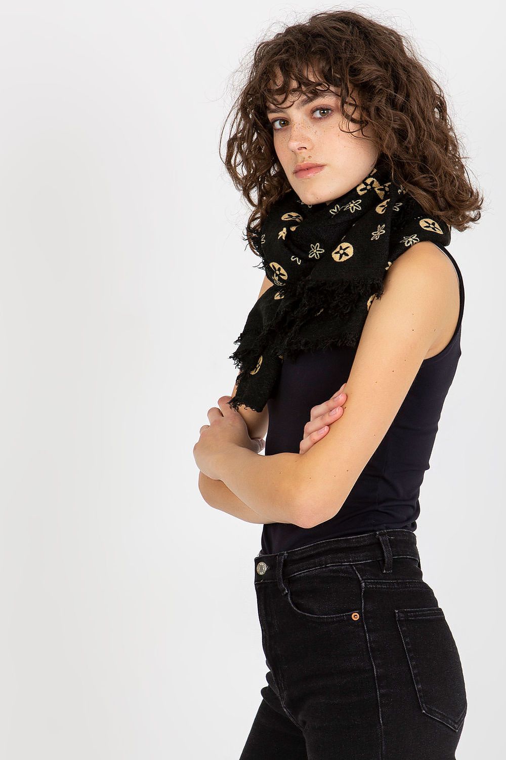 Fashionable woman in a sleek black outfit wearing a luxurious black neckerchief adorned with detailed motifs. She poses confidently, demonstrating the versatile elegance of the accessory.