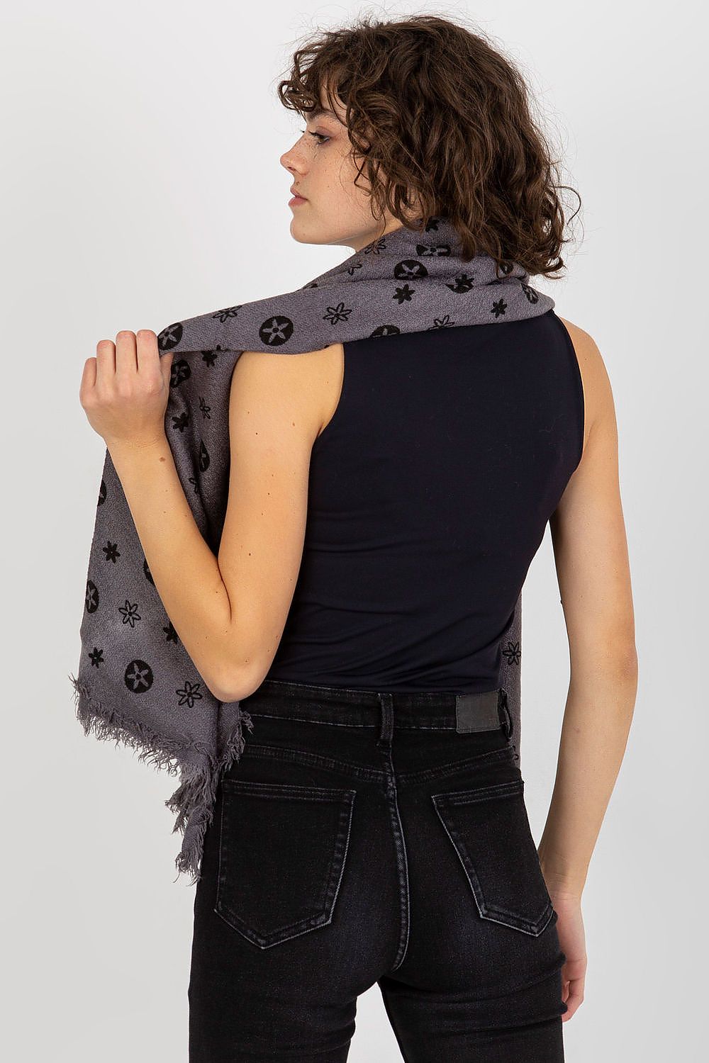 Back view of a graceful model draping a luxury 100% acrylic neckerchief in grey, highlighting its intricate design and luxurious texture.