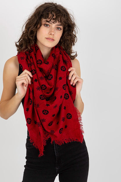 Sophisticated model holding a vibrant red luxury neckerchief with intricate black designs, embodying chic style.