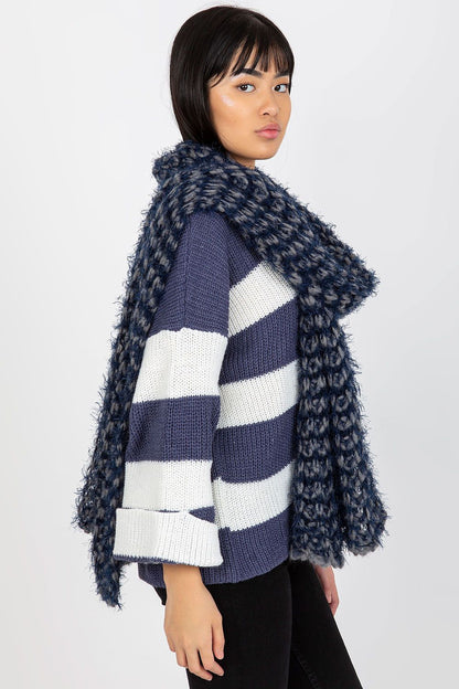 Elegant side view of a model wearing a knitted acrylic scarf featuring a pattern of navy and grey, exuding warmth and sophistication.