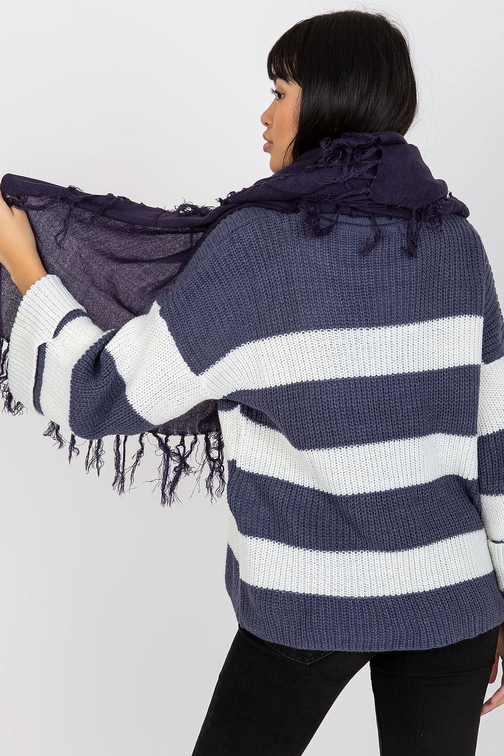 Sophisticated woman featuring a luxurious navy shawl scarf with tassels, paired with a stylish striped sweater, epitomising modern elegance.