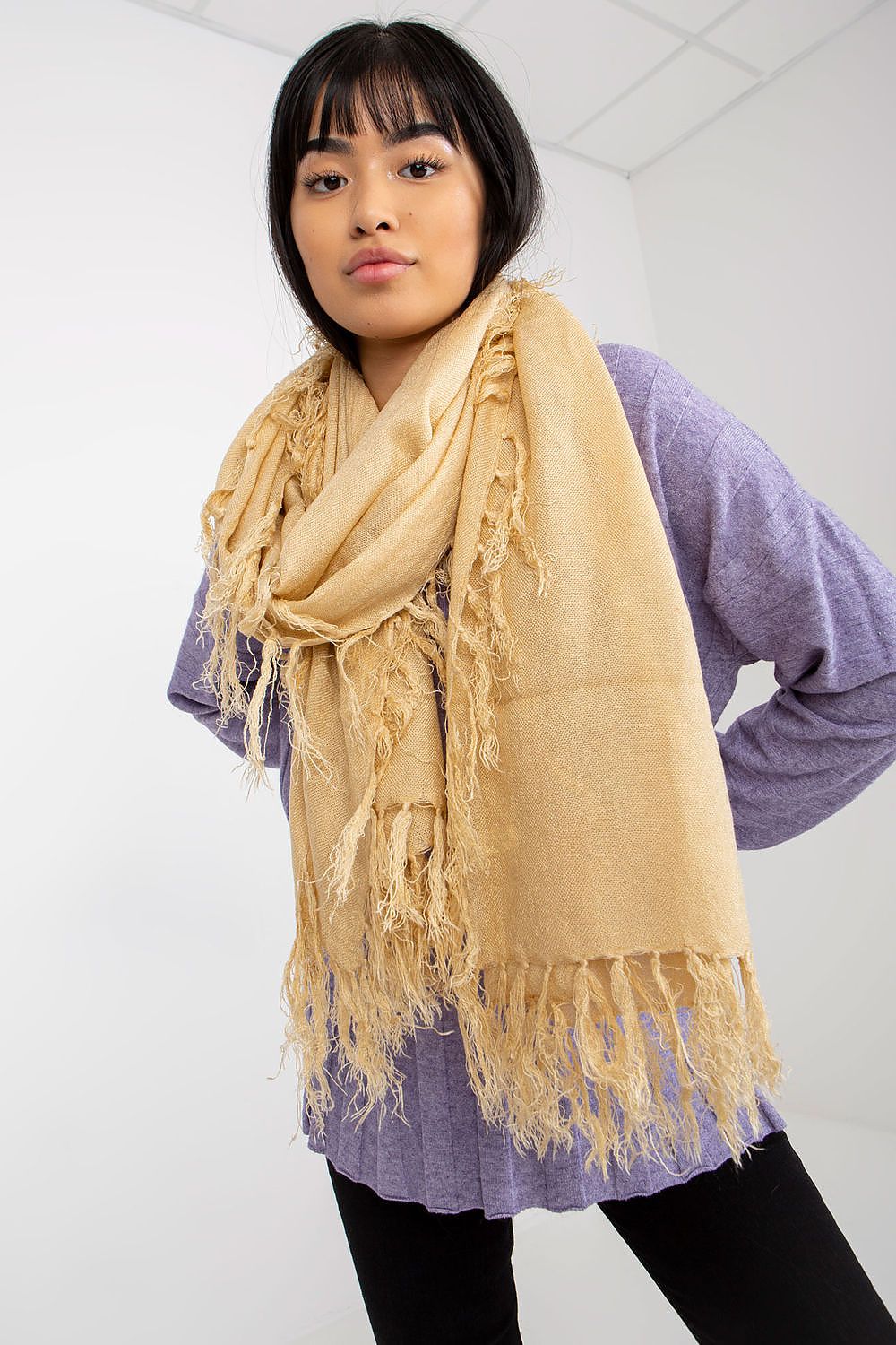 Gorgeous golden acrylic shawl scarf with exquisite tassels, worn by a model, offering an opulent touch to casual and formal attire.