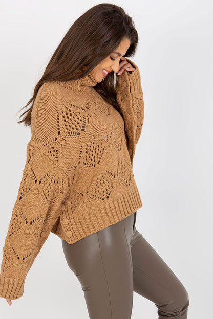 Luxury openwork turtleneck sweater in rich camel colour, featuring wide sleeves and delicate knit patterns, styled with fitted leather trousers.