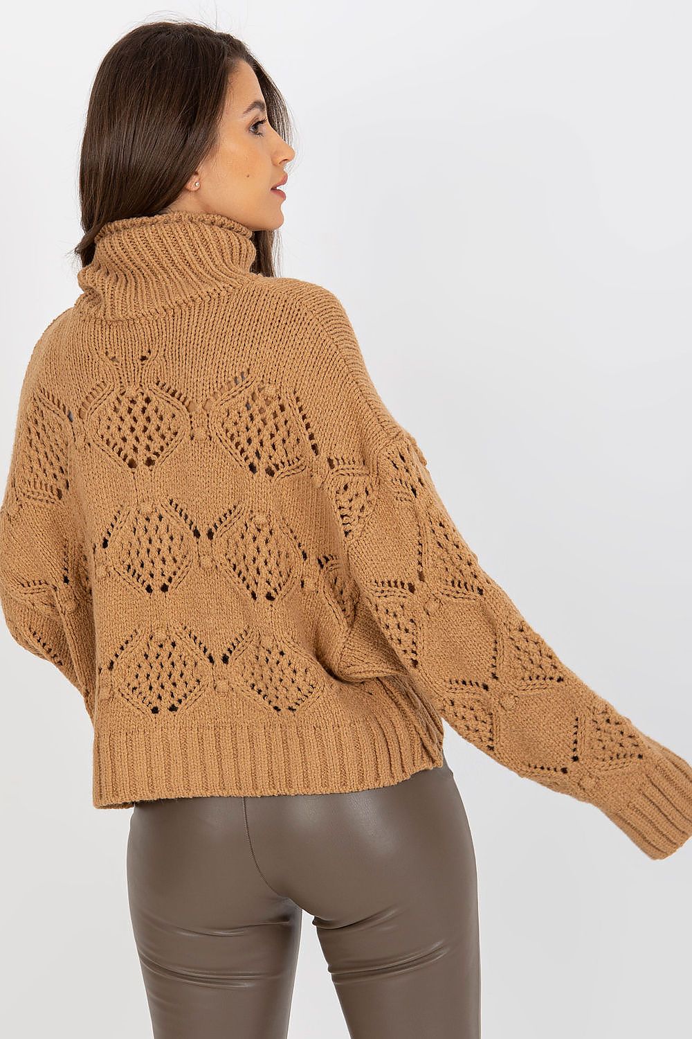 Back view of a luxury openwork turtleneck sweater, showcasing intricate knit detailing and relaxed fit, paired elegantly with leather pants for a chic ensemble.
