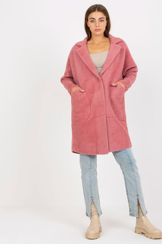 Elegant women's angora wool blend coat in soft pink, featuring long sleeves and slip pockets, styled with light jeans and chic boots.