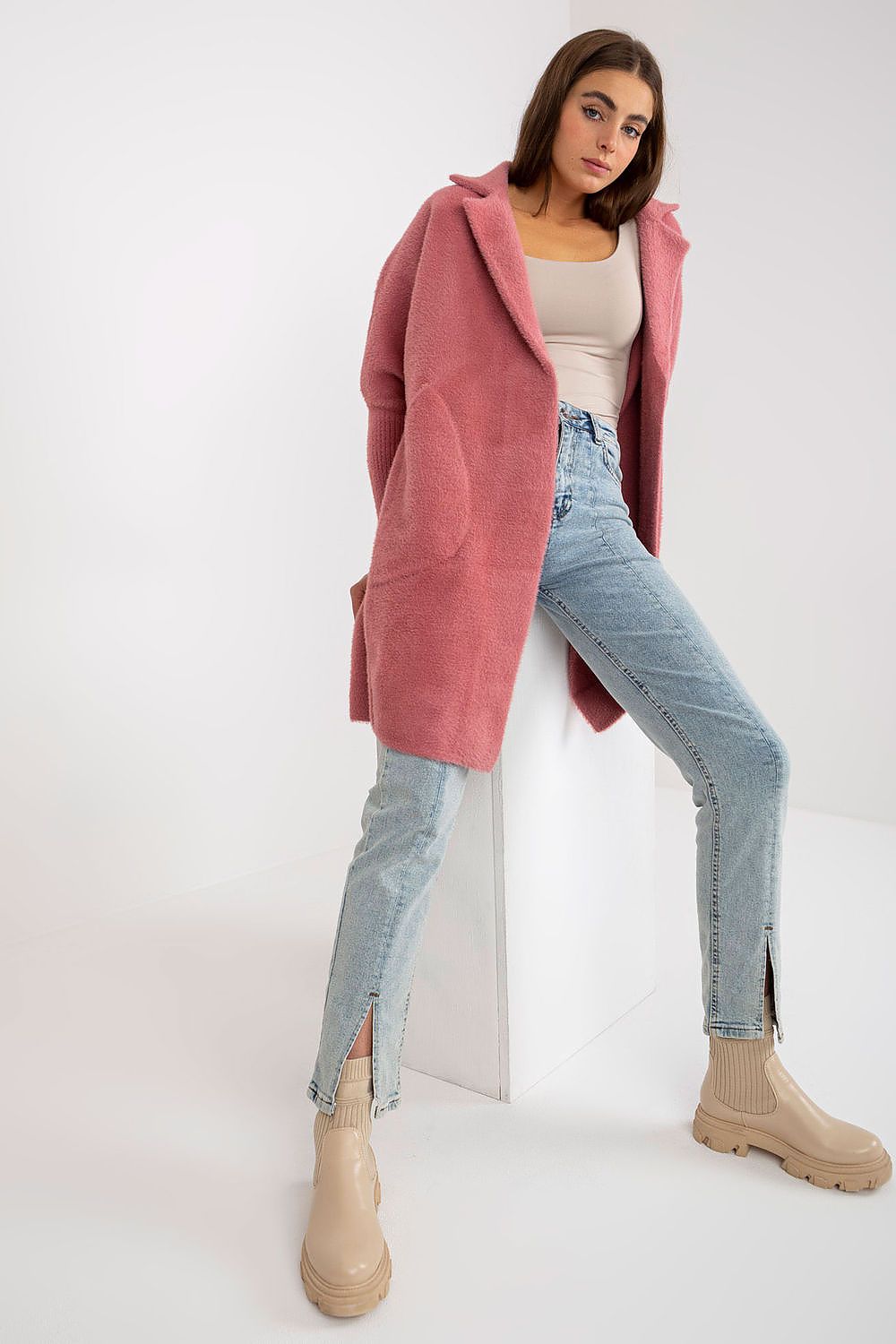 Sophisticated women's angora wool blend coat in pink, showcasing a relaxed fit, long sleeves, and slip pockets, elegantly paired with light denim and stylish footwear.