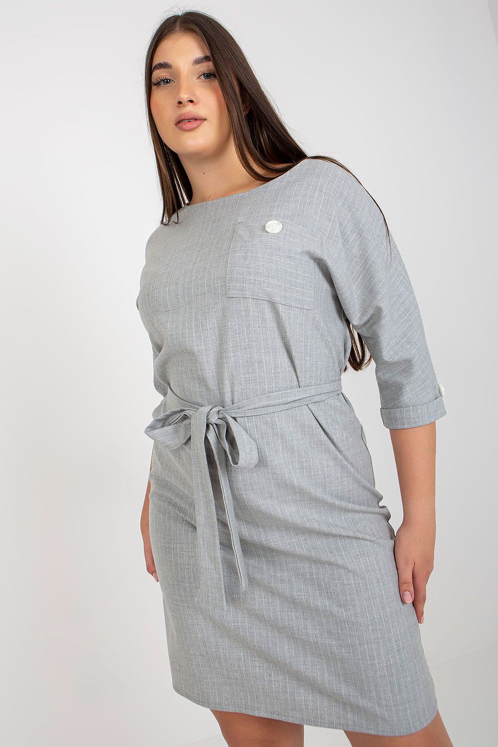 Chic plus size pencil dress in a light grey fabric with a textured stripe, featuring a round neckline, 3/4 sleeves, and a fashionable tie belt, embodying modern luxury.