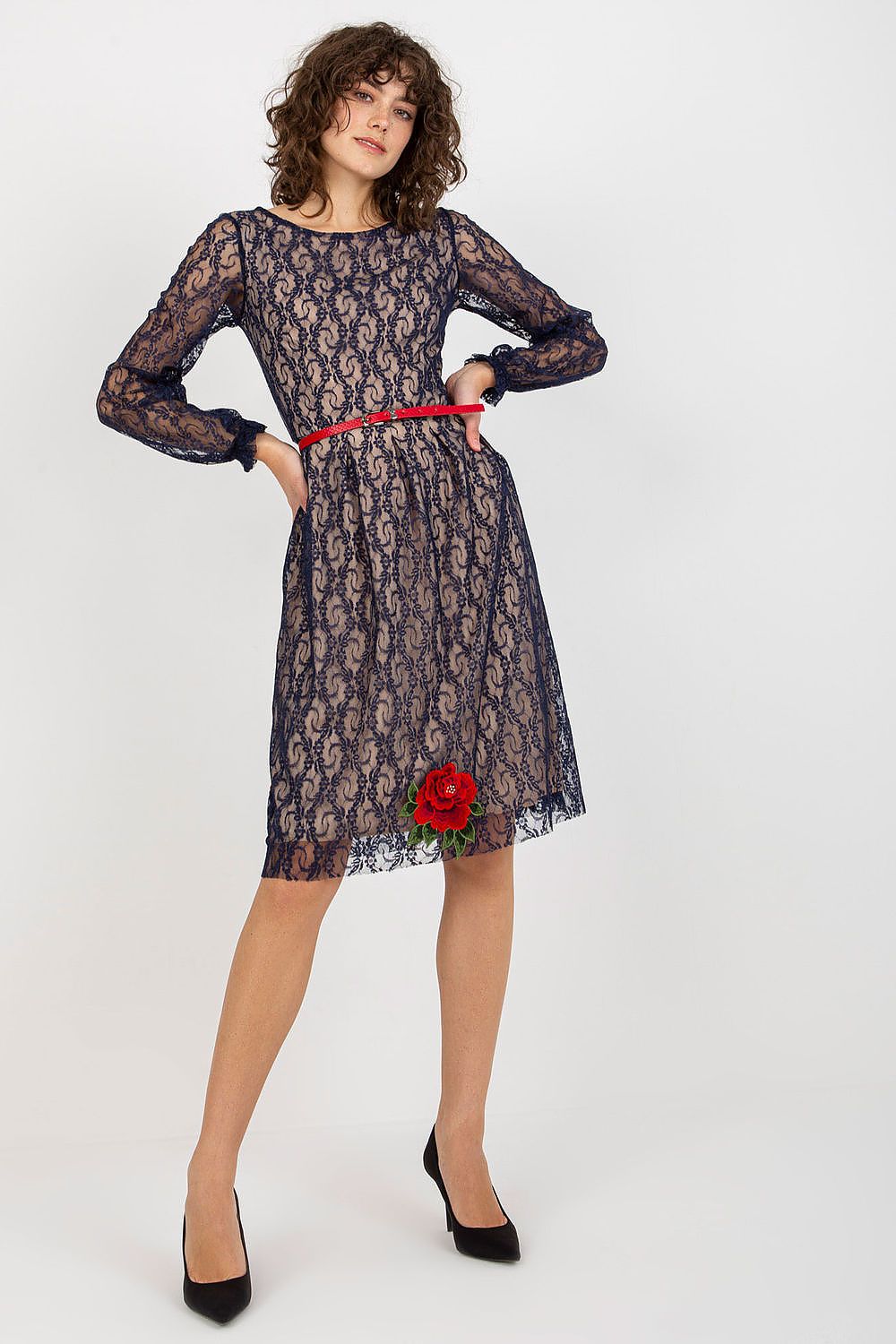 Elegant lace evening dress with long sleeves, featuring floral embellishments and a red belt, showcased against a clean backdrop.